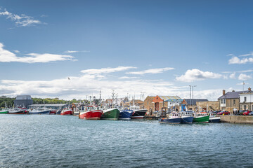 Obraz premium Several colourful fishing boats moored in Howth harbour. Phishing and shellfish fishing equipment on fishing boats, Dublin, Ireland