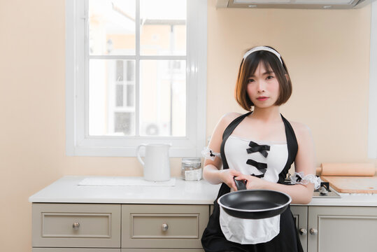 Portrait of beautiful asian sexy woman in the kitchen room,Thailand people,Pose for take a picture,Maid dress costume