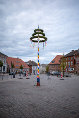 colorfully decorated maypole stands on a marketplace