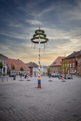 colorfully decorated maypole stands on a marketplace - obrazy, fototapety, plakaty