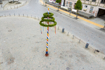  colorfully decorated maypole stands on a marketplace
