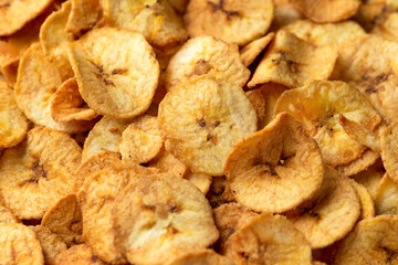 Sweet dried banana chips, snack background, texture