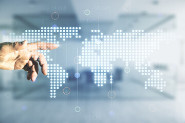 Man hand working with abstract creative world map interface on blurred office background, international trading concept. Multiexposure