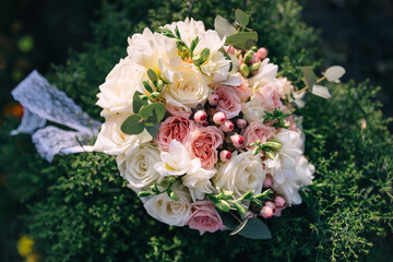 Wedding bouquet with pink flowers lies on green grass