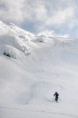 Athletic snowboarder ride down the untouched powder snow. Picturesque snow covered mountain scenery surrounds