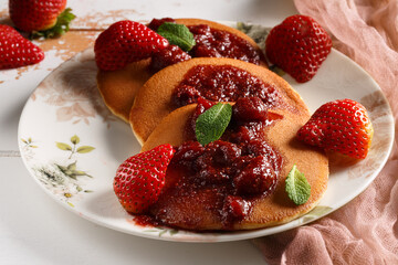 Les crêpes sur une assiette couvert de fraises et confiture de fraise