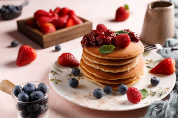 Les crêpes sur une assiette couvert de fraises, myrtilles et confiture de fraise
