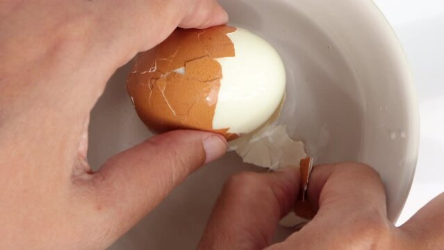 Closeup of peel the chicken egg from the shell for cooking. Home cooking.
