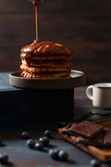Crêpes sur une assiette et le chocolat chaud à coté. Le chocolat coule sur les crêpes.