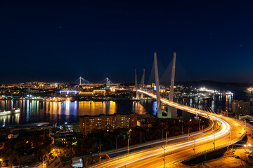 Fototapeta na wymiar Night Vladivostok. Top view of the city, Golden bridge, Golden Horn bay, and the bridge Russian on the horizon in night illumination. Far East, Russia