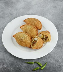 Kue pastel, traditional savory snack from Indonesia filled with carrots, potatoes and egg, eat with chili or sauce. Selective focus