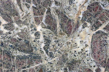old marble texture in black color with splashes of different colors with many cracks, background, close-up