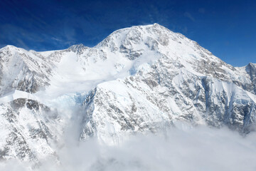 Denali, the tallest mountain in North America, rises above the clouds in the Alaska Range.