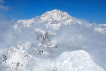 Fototapeta na wymiar Denali, the tallest mountain in North America, rises above the clouds in the Alaska Range.