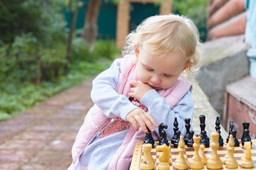 child prodigy plays chess. The concept of development, training, education - obrazy, fototapety, plakaty