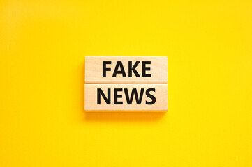 Fake news symbol. Wooden blocks with concept words Fake news on beautiful yellow background. Business media and fake news concept. Copy space.