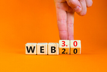 WEB 2.0 or 3.0 symbol. Businessman turns wooden cubes and changes concept words WEB 2.0 to WEB 3.0. Beautiful orange table orange background copy space. Business technology and WEB 2.0 or 3.0 concept.