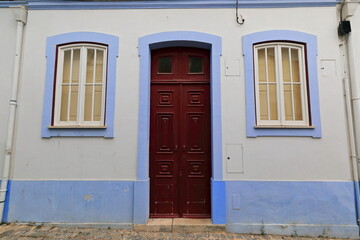 Mauve framed white wall-one story townhouse-maroon wooden door. Lagos-Portugal-223