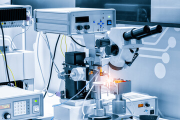 Chip testing equipment. Manufacturing of microchips. A close-up study of a test sample of a transistor chip under a microscope in the laboratory. Automation of production.