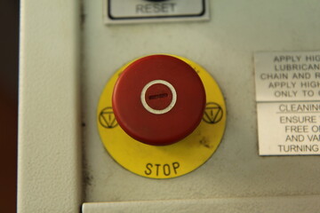 Red button and 'stop' on a yellow circle.  Equipment.