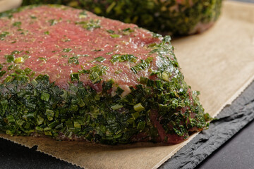 Pork rump steak with herb coating, close up.