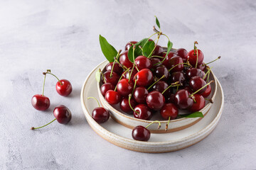 Fresh ripe cherries in two ceramic plates on a light background. Close-up.