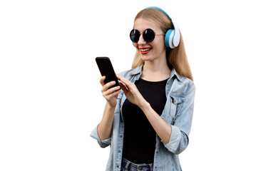 Portrait of young woman with smartphone listening to music in wireless headphones isolated on white background