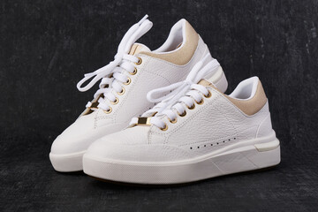 Stylish leather sneakers on dark background, casual shoes - 502080102