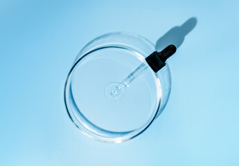Laboratory glass petri with pipette and drop of water, serum, oil, beauty product. Natural...