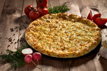 Ossetian pie with cheese and herbs on the table