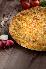 Ossetian pie with cheese and herbs on the table