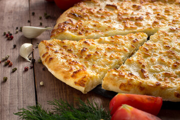 Ossetian pie with cheese and herbs on the table