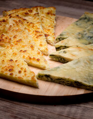 Ossetian pie with cheese and herbs on the table