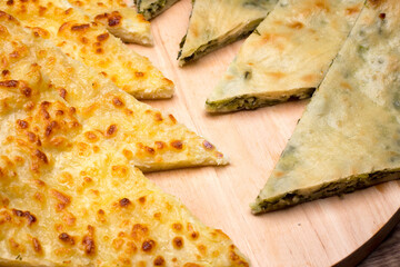 Ossetian pie with cheese and herbs on the table