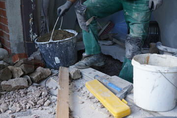 A man worker moving out crushed stones in bucket.