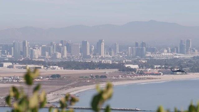 San Diego city skyline, cityscape of downtown with highrise skyscrapers, California coast, USA. View of Coronado island from above, Point Loma vista viewpoint. Helicopter flying mid air in sky.