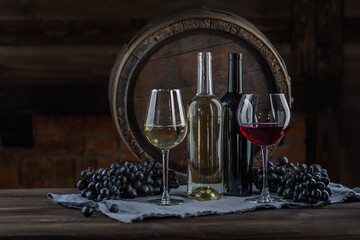 Wine glasses with tall stem. Old oak barrel in a dark wine cellar at the winery. Aging cellaring wine tasting