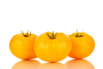 Three ripe yellow tomatoes, close-up, isolated on a white background.