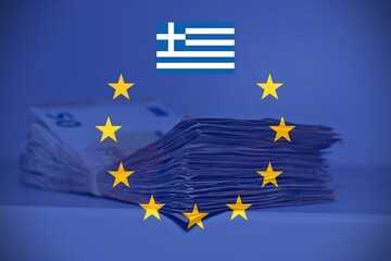 Pile of fifty euros on the table with the European Flag and the Greek Flag, concept of financial help to Greece