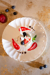coconut dessert with strawberries on a white plate top view