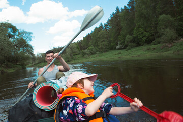 Family kayak trip. Father and daughter rowing boat on the river, a water hike, a summer adventure. Eco-friendly and extreme tourism, active and healthy lifestyle