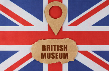 On the flag of Great Britain lies a symbol of geolocation and cardboard with the inscription -...