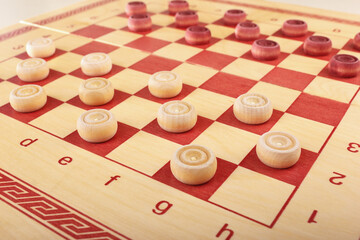 Chessboard with the wooden checkers placed at beginning of game.