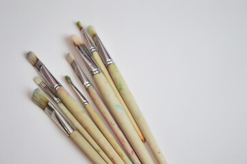 Brushes of different sizes with wooden handles and natural bristles on a white background. Free space for text.