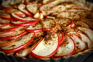 Pieces of apple with cinnamon, close up of open apple pie.