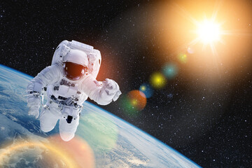 Astronaut in outer space with bright sun and lens flare. National Astronaut Day is an American...