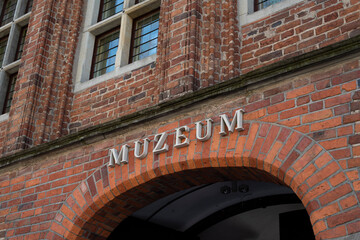 Single word MUZEUM on red brick wall. Sign muzeum on the museum building in Torun, Poland