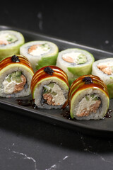 uramaki sushi roll with smoked eel unagi covered by avocado