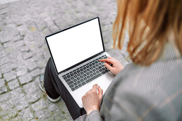  Young 30s blonde business woman working with laptop computer outdoors, empty screen display