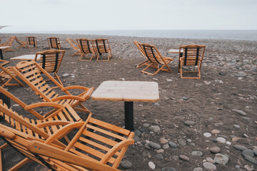 Wooden chairs and table of restaurant overlooking near the sea beach.